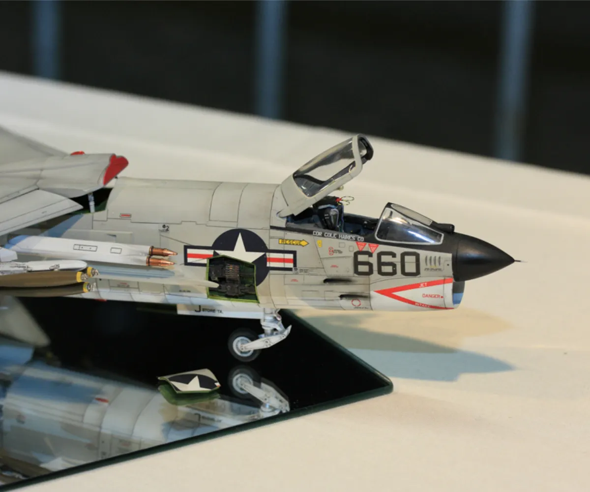 Maquette d'avion de chasse exposée sur un miroir