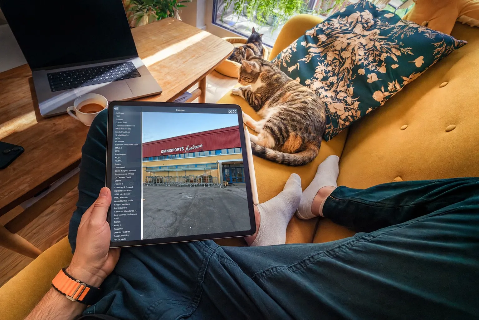 Personne installée dans un fauteuil avec ses chats, parcourant la visite virtuelle sur une tablette